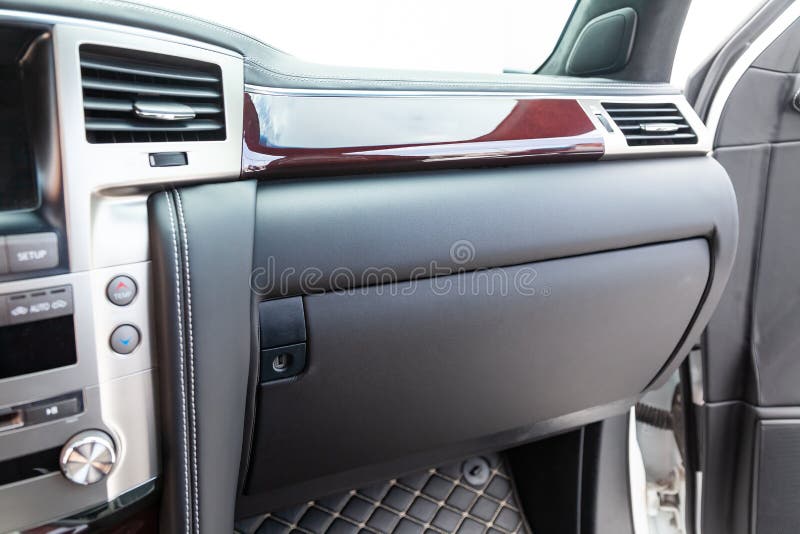 Interior of a luxury car with leather interior overtightened stitching in the form of a diamond of white thread at car glove box