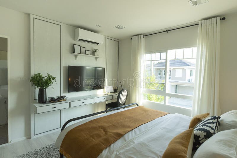 Interior of Master Bedroom with Window and Big TV on the Wall. Stock