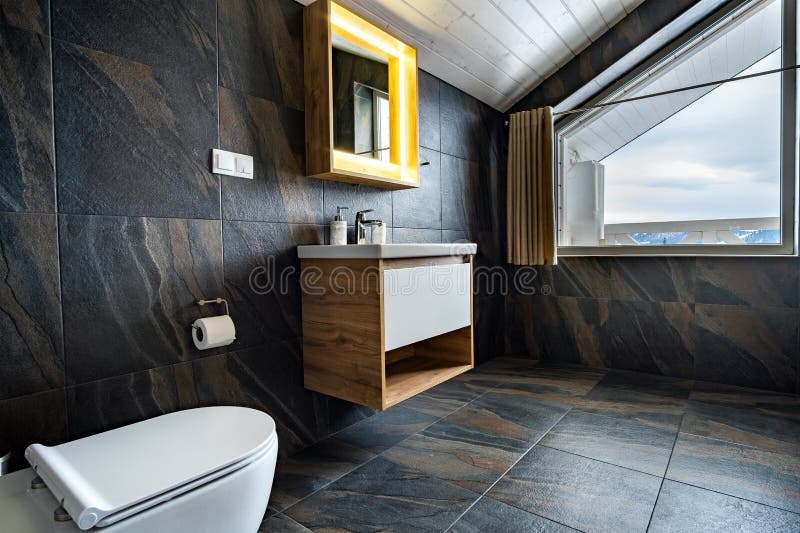 Interior of modern stylish bathroom with black tiled walls, curtain shower place and wooden furniture with wash basin and big