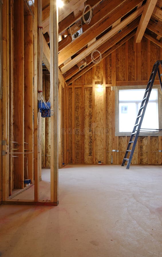 An interior view of a new home under construction with exposed wiring and and a ladder in place. Vertical shot. An interior view of a new home under construction with exposed wiring and and a ladder in place. Vertical shot.