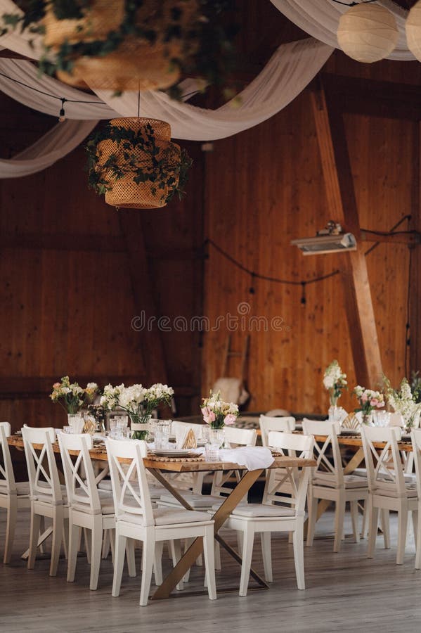 Interior of Restaurant with Wedding Table and White Chairs Adorned with