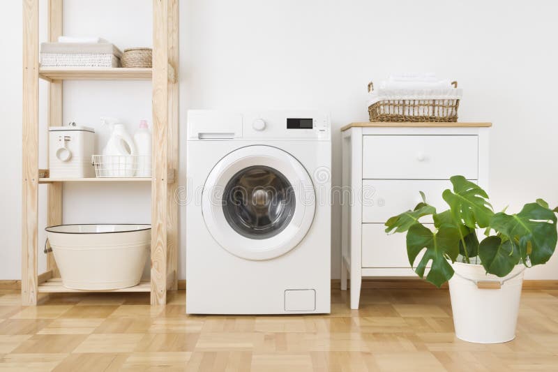 Interior of simple home laundry room with modern washing machine stock photography