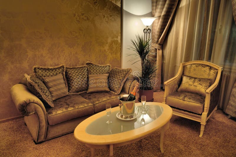 Interior of an exclusive room with stylish furniture, sparkling wine and two glasses on the table. Interior of an exclusive room with stylish furniture, sparkling wine and two glasses on the table