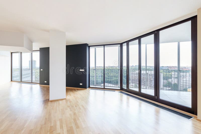 Interior vacío blanco moderno del apartamento del desván con el piso de entarimado y las ventanas panorámicas, pasando por alto l