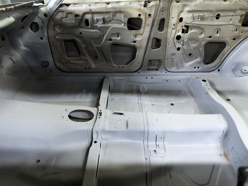 Interior view of disassembled car cabin during the restoration process, showing exposed door structures and freshly primed floor royalty free stock photos