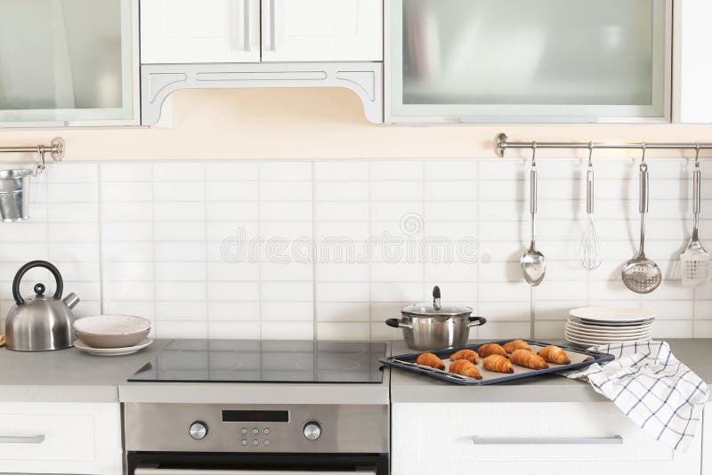Interior à moda da cozinha com forno e grupo de utensílios de cozimento foto de stock Interior à moda da cozinha com forno e grupo de utensílios de cozimento foto de stock
