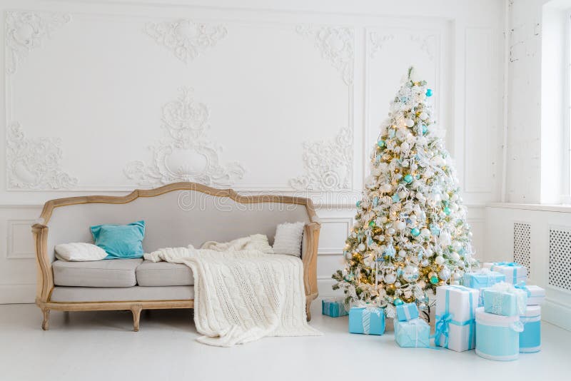 Interior à moda do Natal com um sofá elegante Casa do conforto Apresenta presentes debaixo da árvore na sala de visitas