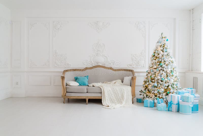 Interior à moda do Natal com um sofá elegante Casa do conforto Apresenta presentes debaixo da árvore na sala de visitas