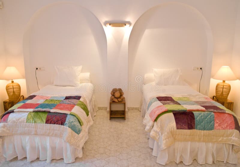 An interior view of a bedroom with two twin beds. An interior view of a bedroom with two twin beds.