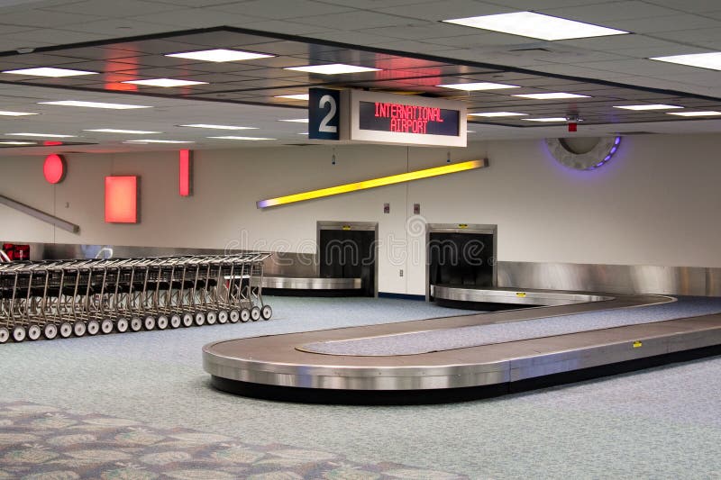 Empty baggage claim carousel. International Airport. Baggage cars. Waiting for the plane to land and unload. Empty baggage claim carousel. International Airport. Baggage cars. Waiting for the plane to land and unload.