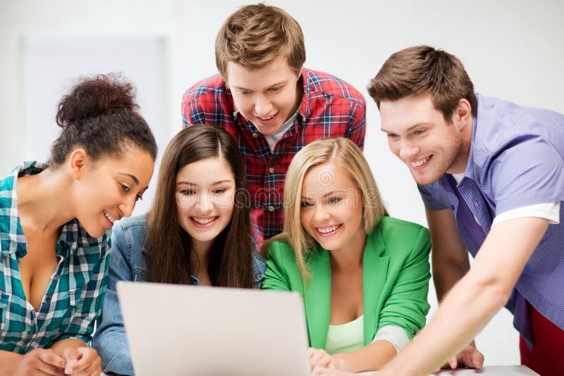 Internationale Studenten, die Laptop an der Schule betrachten stockbild Internationale Studenten, die Laptop an der Schule betrachten stockbild