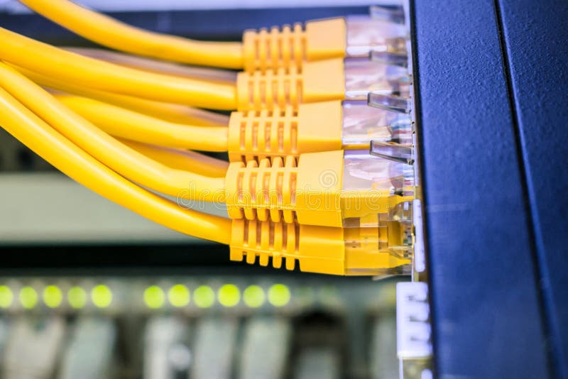 Internet cable is in the datacenter server room. Several yellow network wires are connected to the switching hub ports. stock photo Internet cable is in the datacenter server room. Several yellow network wires are connected to the switching hub ports. stock photo