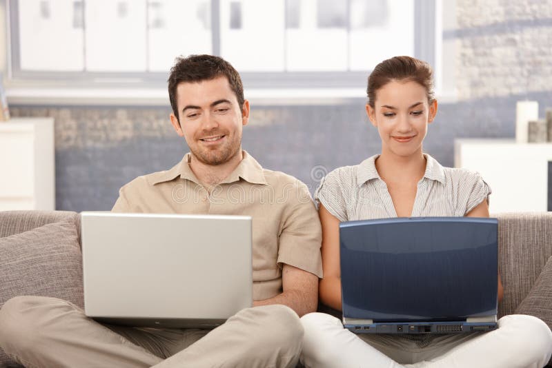 Internet novo da consultação dos pares em casa que sorri imagens de stock Internet novo da consultação dos pares em casa que sorri imagens de stock