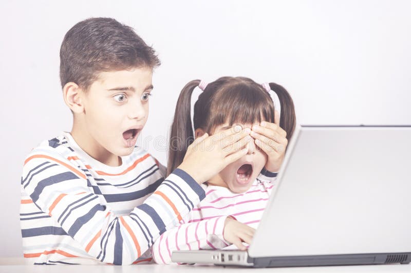 Little boy protects his sister from watching inappropriate content while using a computer. Little boy protects his sister from watching inappropriate content while using a computer