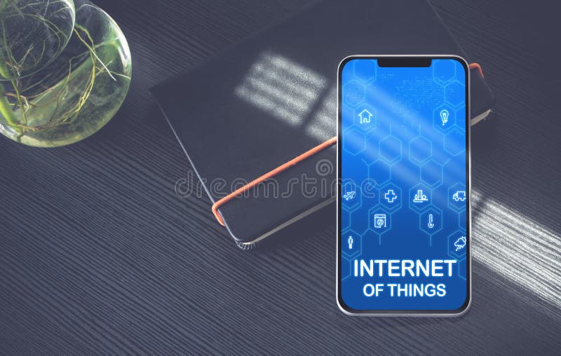 Internetul obiectelor include pictograme pe ecranul telefonului mobil, pe notebook-ul negru lângă fereastră, cu lumina soarelui pe royalty free stock photos