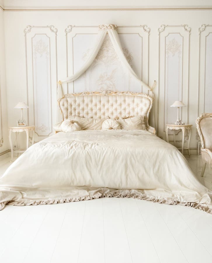 Interno bianco lussuoso con il letto classico immagine stock Interno bianco lussuoso con il letto classico immagine stock
