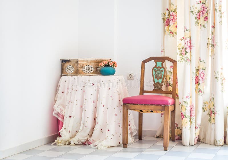 Interno d'annata di stile con la tavola, la sedia scolpita e la tenda floreale fotografia stock Interno d'annata di stile con la tavola, la sedia scolpita e la tenda floreale fotografia stock