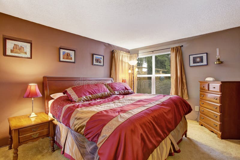 Interno della camera da letto con il bello letto in rosso e moca fotografia stock libera da diritti Interno della camera da letto con il bello letto in rosso e moca fotografia stock libera da diritti