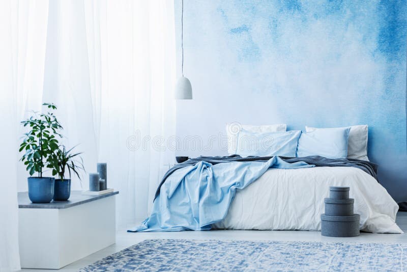 Interno della camera da letto degli azzurri con letto matrimoniale, le piante e le scatole grige immagini stock libere da diritti