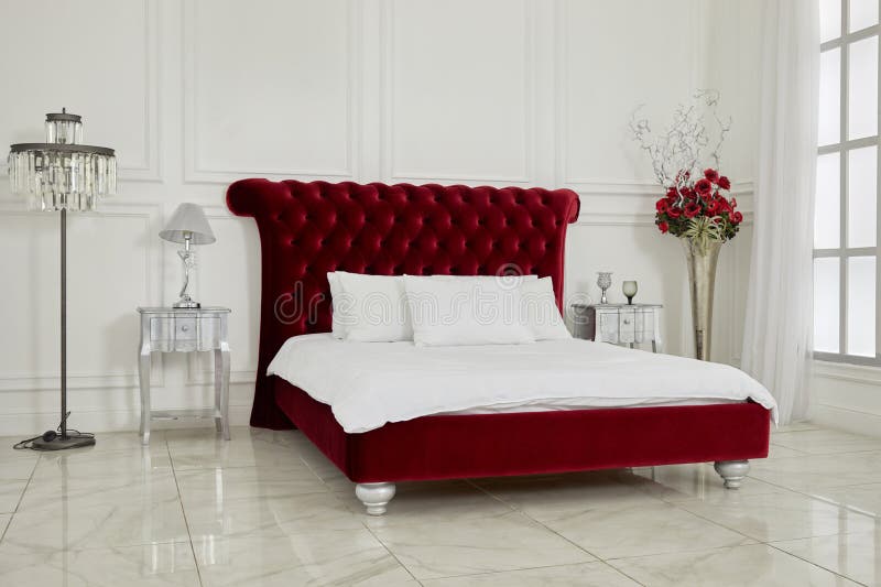 Interno di spaziosa camera da letto bianca con grande rosso immagini stock libere da diritti
