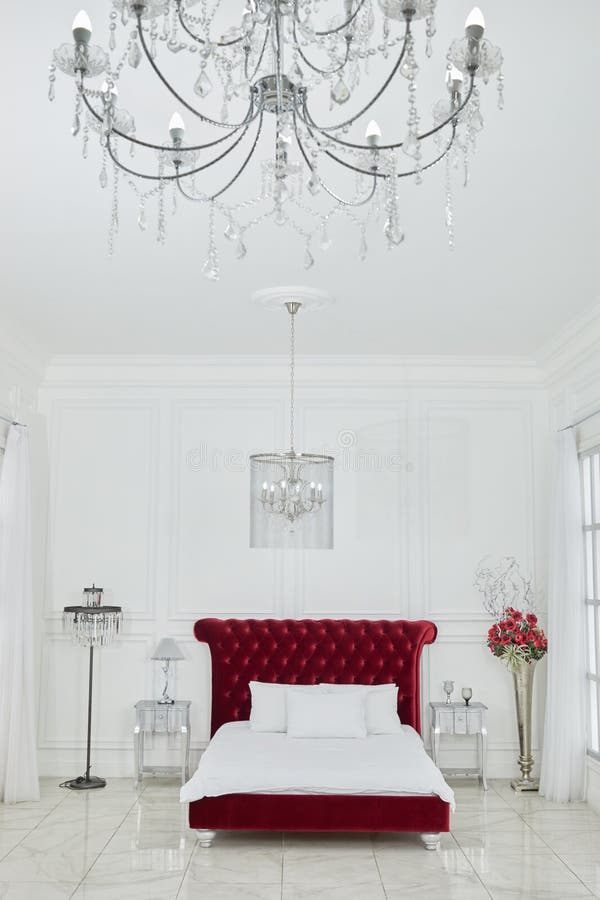 Interno di spaziosa camera da letto bianca con grande rosso fotografia stock