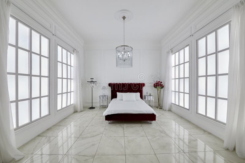 Interno di spaziosa camera da letto bianca con grande rosso fotografia stock libera da diritti
