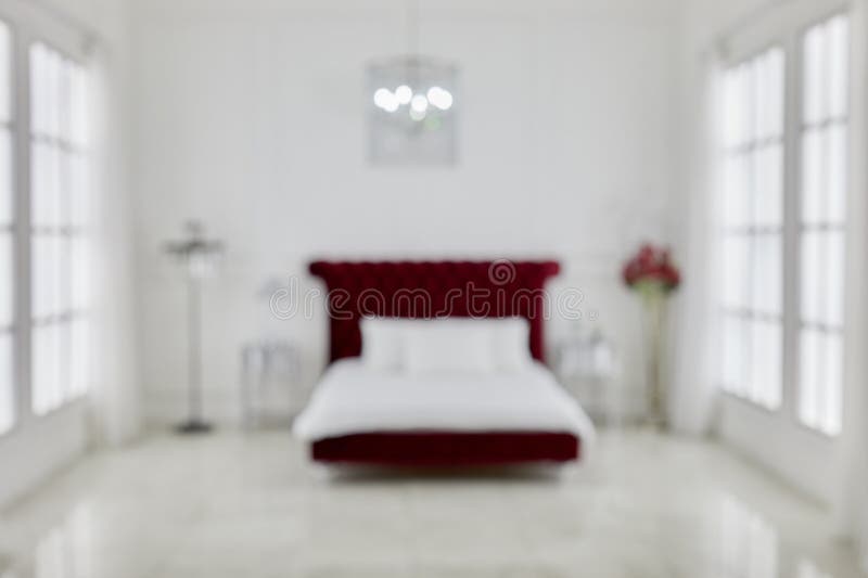 Interno di spaziosa camera da letto bianca con grande rosso fotografia stock