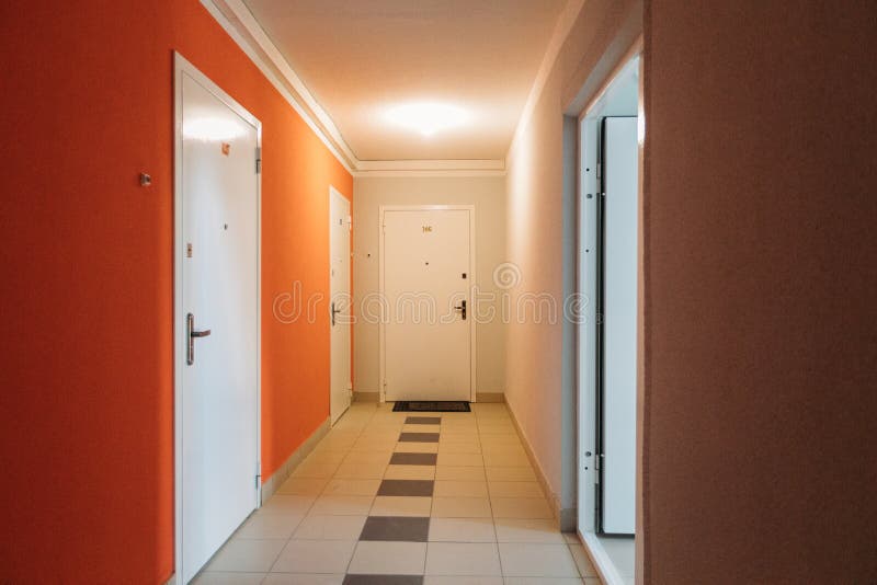 Interno di un edificio residenziale a colori bianco e arancione con porte d'ingresso