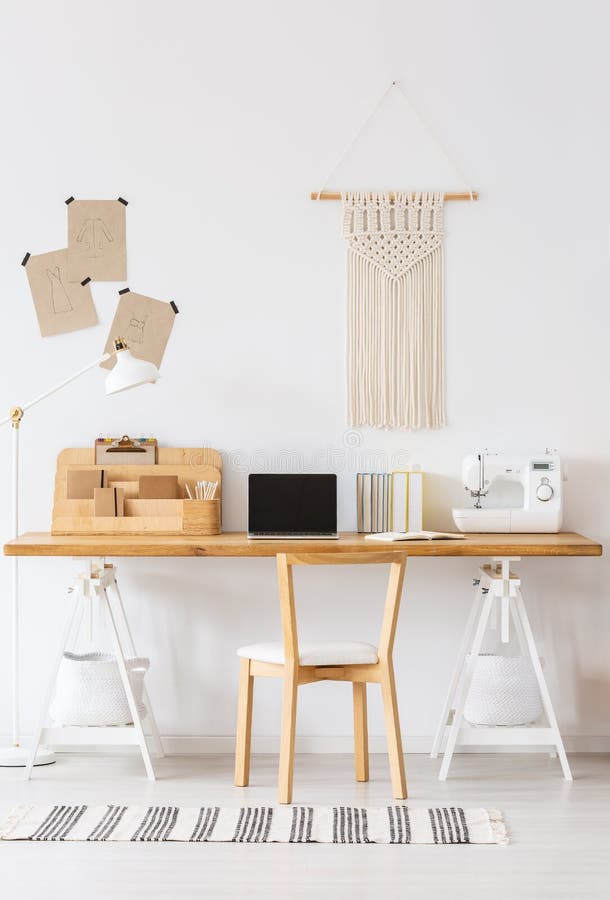 Interno domestico moderno di offfice con uno scrittorio, un computer portatile, una macchina per cucire, una sedia e un macramè s immagini stock Interno domestico moderno di offfice con uno scrittorio, un computer portatile, una macchina per cucire, una sedia e un macramè s immagini stock