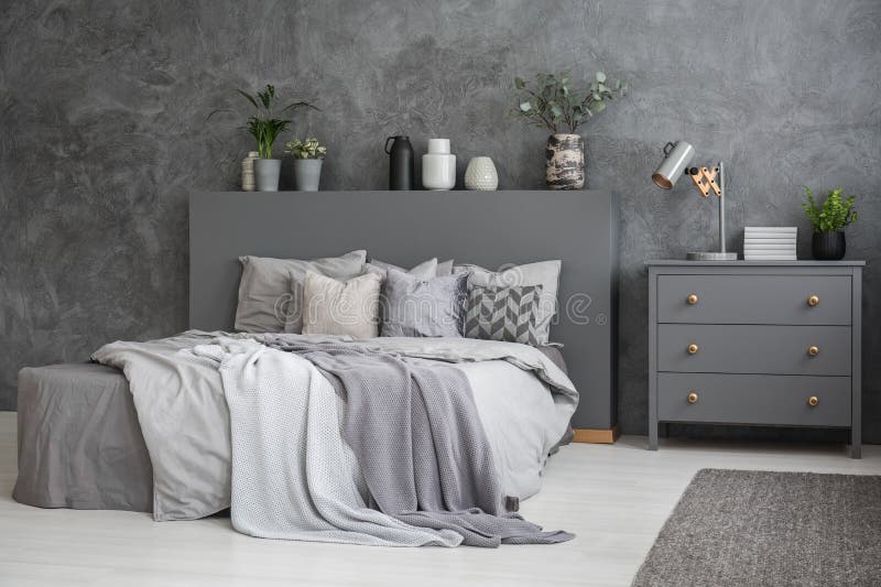 Interno grigio e bianco spazioso della camera da letto con il grande letto con il letto