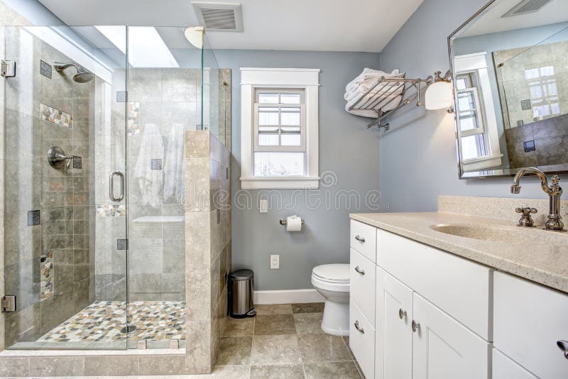 Interno moderno del bagno con la doccia di vetro della porta