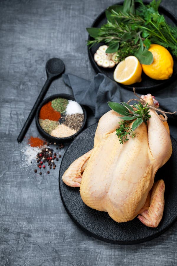 Intero pollo, erbe, spezie e limone crudi fotografia stock libera da diritti Intero pollo, erbe, spezie e limone crudi fotografia stock libera da diritti