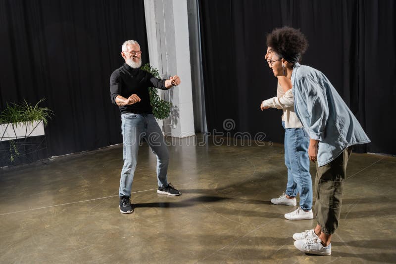 Interracial actresses laughing near bearded art royalty free stock image