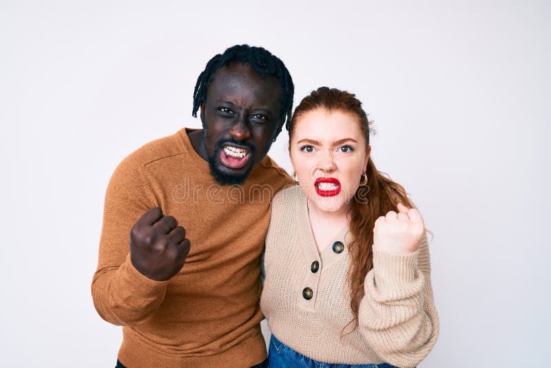 Interracial Couple Wearing Casual Clothes Angry And Mad Raising Fist