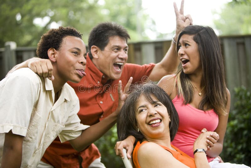 Interracial family making silly gestures posing for photograph. Interracial family making silly gestures posing for photograph