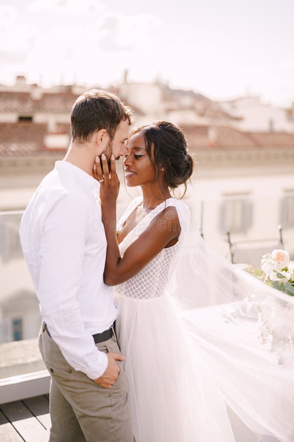 Wedding Couple. Caucasian Groom and African-American Bride Cuddling on a Rooftop in Sunset Sunlight Stock Image - of caucasian, gorgeous: 183852475