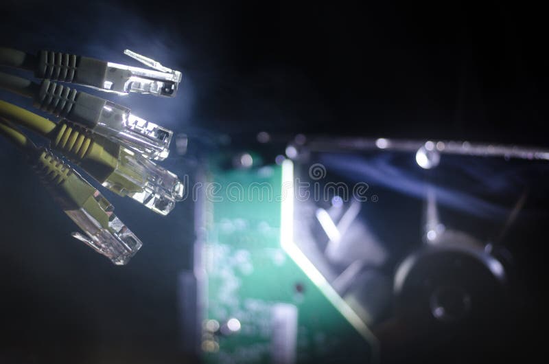Interruptor de rede e cabos ethernet, símbolo de comunicações globais A rede colorida cabografa no fundo escuro com luzes e smo imagens de stock Interruptor de rede e cabos ethernet, símbolo de comunicações globais A rede colorida cabografa no fundo escuro com luzes e smo imagens de stock
