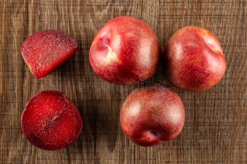 Interspecific plommoner för ny pluot på brunt trä arkivbilder Interspecific plommoner för ny pluot på brunt trä arkivbilder