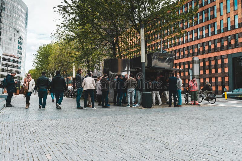 Intervallo di pranzo alla gente di Zuidas sulla via nella linea per un panino del falafel fotografia stock Intervallo di pranzo alla gente di Zuidas sulla via nella linea per un panino del falafel fotografia stock