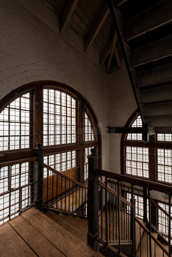 Intricate Cast Iron Staircase & Large Windows - Abandoned Tewksbury State Hospital - Massachusetts royaltyfri bild