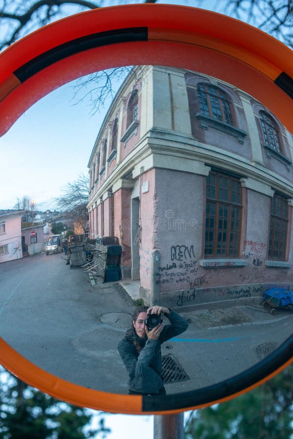 Urban Reflection: Photographer Captured in Street Mirror royalty free stock photography