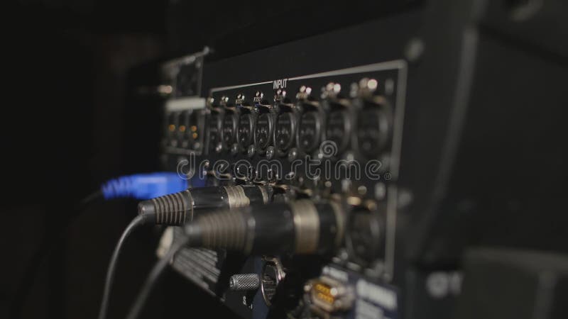 Introduzindo cabos audio profissionais de XLR ao painel traseiro do registrador profissional imagem de stock Introduzindo cabos audio profissionais de XLR ao painel traseiro do registrador profissional imagem de stock
