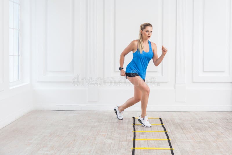 Intégrale de la belle jeune femme blonde sportive sportive dans des shorts noirs et du dessus bleu sont allumées la cardio- séanc image stock Intégrale de la belle jeune femme blonde sportive sportive dans des shorts noirs et du dessus bleu sont allumées la cardio- séanc image stock
