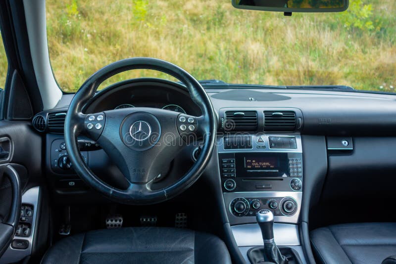 Cluj-Napoca, Romania - August 08, 2017: manual transmission gear knob with chromed ornaments, switched in first gear and temperature unit control, sport steering wheel, electric window command buttons. Cluj-Napoca, Romania - August 08, 2017: manual transmission gear knob with chromed ornaments, switched in first gear and temperature unit control, sport steering wheel, electric window command buttons