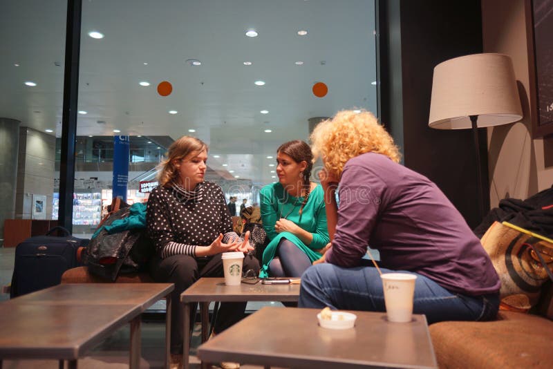 SAINT PETERSBURG - SEP 01: friendly chat in Starbucks Cafe on September 01, 2014 in Saint Petersburg, Russia. Starbucks is the largest coffeehouse company in the world, with more then 23000 stores. SAINT PETERSBURG - SEP 01: friendly chat in Starbucks Cafe on September 01, 2014 in Saint Petersburg, Russia. Starbucks is the largest coffeehouse company in the world, with more then 23000 stores