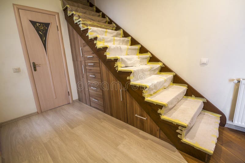 Intérieur de maison avec l'escalier en bois de chêne couvert de couverture protectrice de tissu pendant les travaux de rénovation photos stock Intérieur de maison avec l'escalier en bois de chêne couvert de couverture protectrice de tissu pendant les travaux de rénovation photos stock