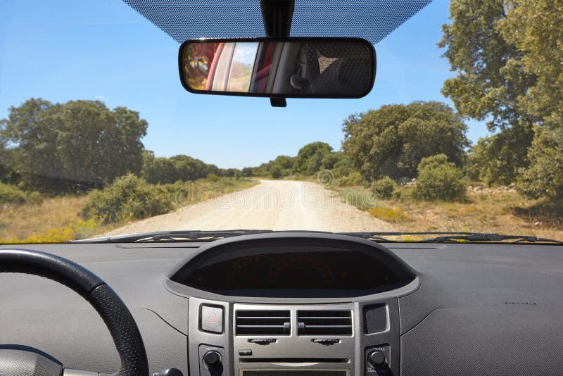 Intérieur de voiture et route de gravier un jour ensoleillé photographie stock Intérieur de voiture et route de gravier un jour ensoleillé photographie stock