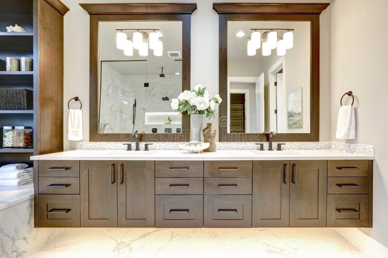 Intérieur principal de salle de bains dans la maison moderne de luxe avec les coffrets foncés de bois dur, le baquet blanc et la photo libre de droits