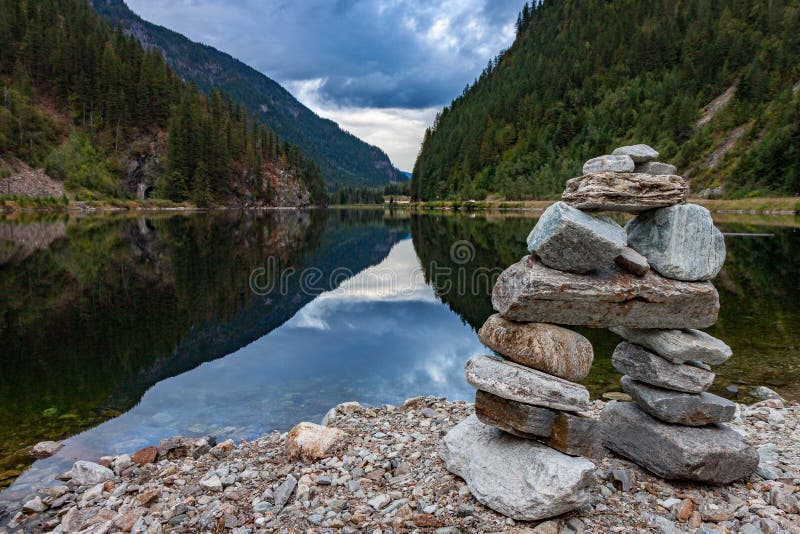Rock Inukshuk at Griffin Lake British Columbia. An inukshuk overlooks beautiful Griffin Lake in eastern British Columbia stock photo Rock Inukshuk at Griffin Lake British Columbia. An inukshuk overlooks beautiful Griffin Lake in eastern British Columbia stock photo