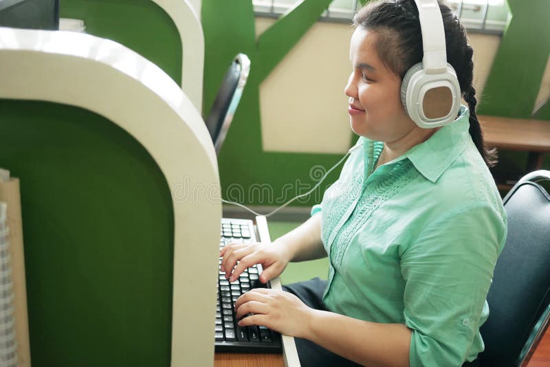 Invaliditeit jonge blinde vrouw die blij is met het computertoetsenbord dat op een creatieve werkplek werkt